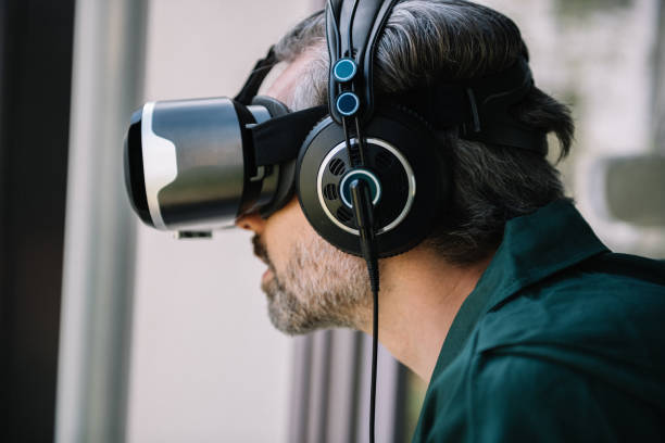 istock grey haired man with virtual realty simulator and headphones 1149071327