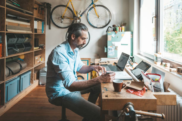 istock handsome creative man drawing in sketchbook in homeoffice 1149072331