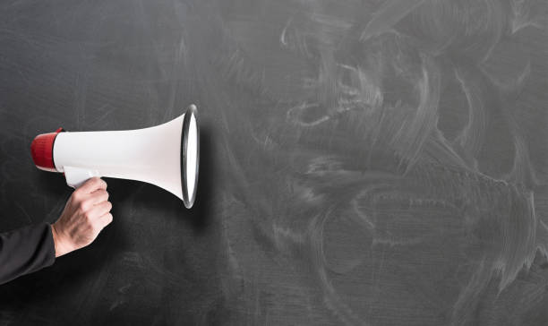 istock hand holding red and white megaphone against chalkboard 1149072755