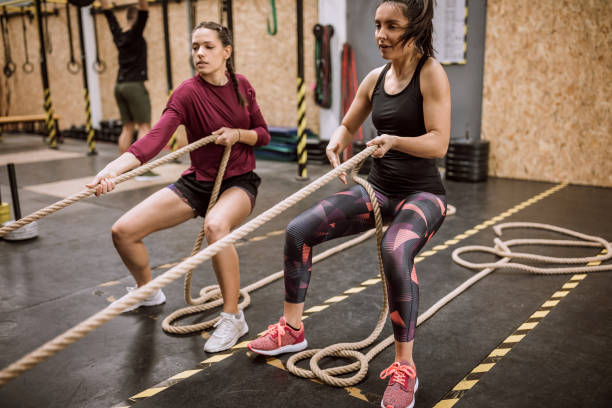 istock Women Exercising with Battle Rope in Gym 1149072900