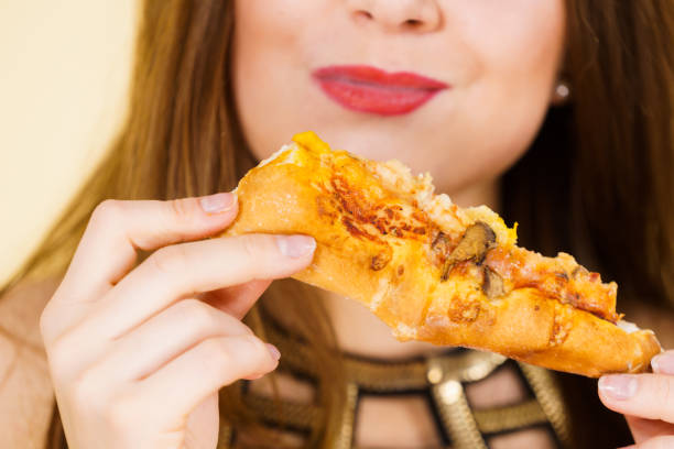 istock Woman eating hot pizza slice 1149073086