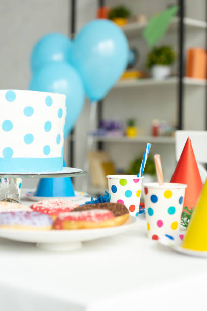 istock selective focus of birthday cake, donuts and party decorations on table 1149074796