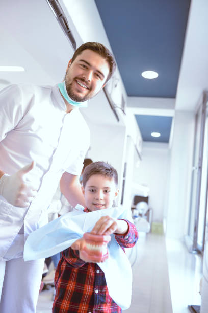 istock Dentist Encouraging Kid To Play With Prosthetic Teeth 1149075647