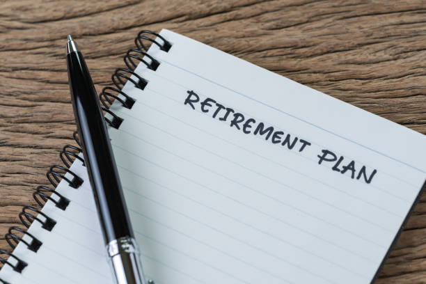 istock Empty small notepad with pen and handwriting headline as Retirement Plan on wood table in soft vintage tone, planning for saving and investment for the future 1149079155