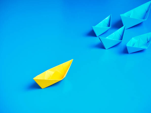 istock Yellow and Blue paper ship on blue background. Business for innovative solution concept 1149079232