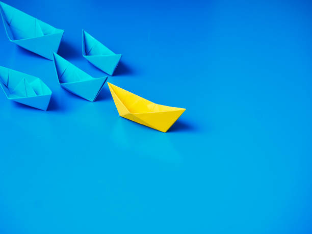 istock Yellow and Blue paper ship on blue background. Business for innovative solution concept 1149079233