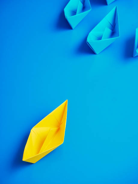 istock Yellow and Blue paper ship on blue background. Business for innovative solution concept 1149079244