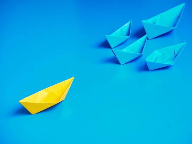 istock Yellow and Blue paper ship on blue background. Business for innovative solution concept 1149079253