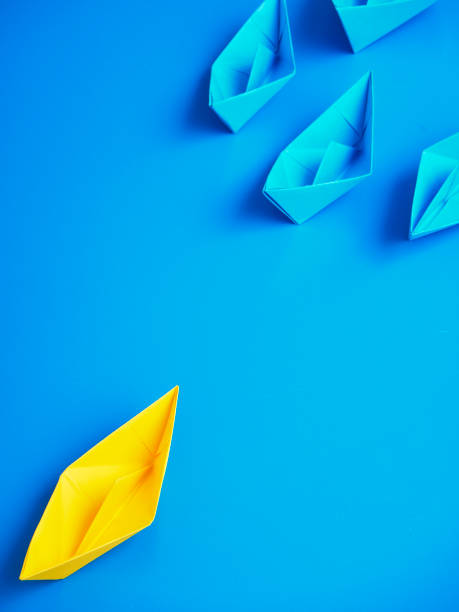 istock Yellow and Blue paper ship on blue background. Business for innovative solution concept 1149079254