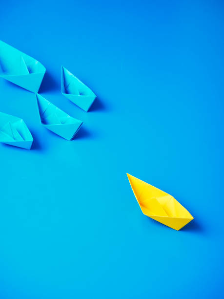 istock Yellow and Blue paper ship on blue background. Business for innovative solution concept 1149079255