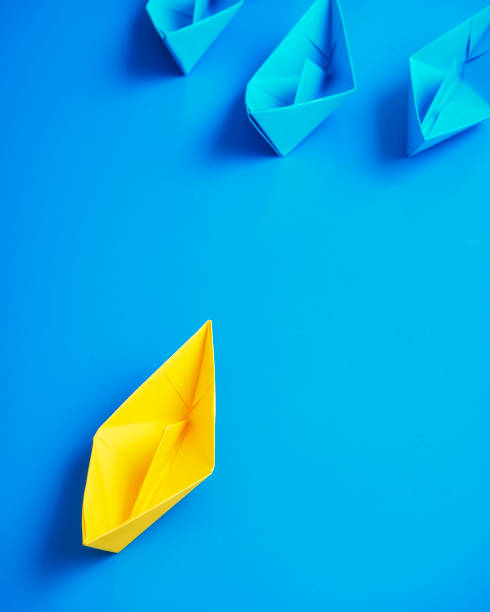 istock Yellow and Blue paper ship on blue background. Business for innovative solution concept 1149079266