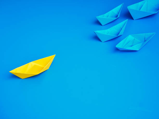 istock Yellow and Blue paper ship on blue background. Business for innovative solution concept 1149079277