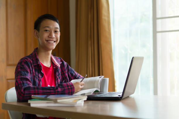 istock Happy asia student learning language online on laptop at home 1149080021