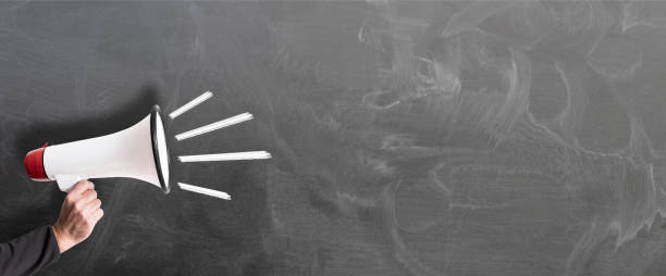 istock hand holding red and white megaphone against chalkboard 1149080592