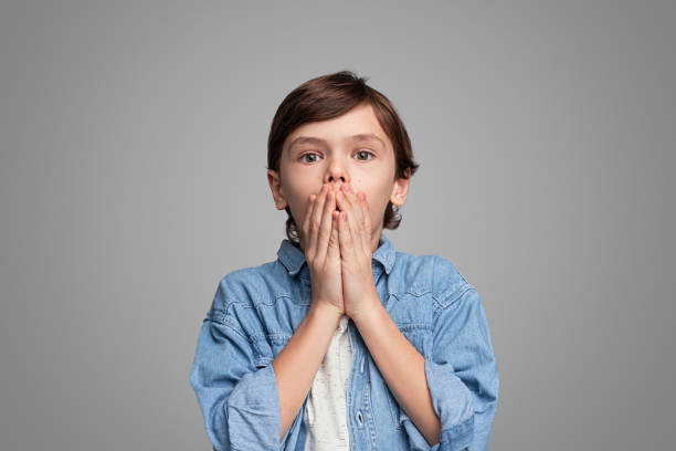 Shocked boy covering mouth