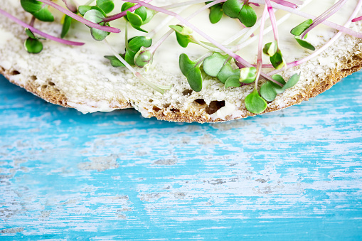 closeup of an healthy sandwich or bread with microgreens like radish seedlings or sprouts on it