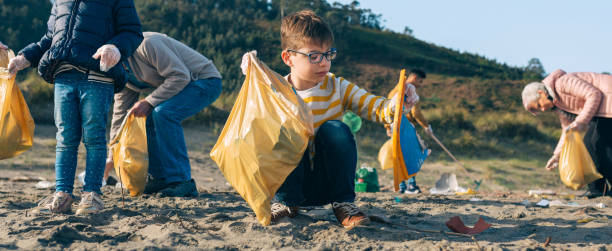 volunteers cleaning the beach - wasting time imagens e fotografias de stock
