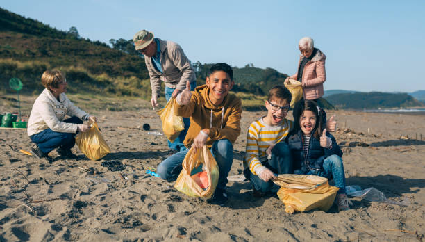 istock Young man and children cleaning the beach 1149083903