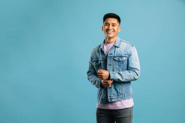istock Fashionable Young Man In Front of a Blue Backdrop 1149084980