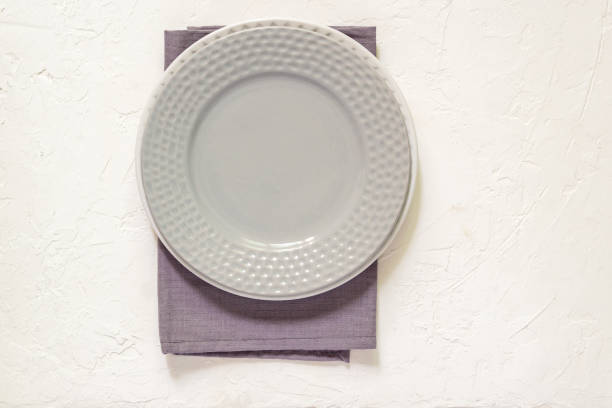 istock Top view of empty served plates, gray textile napkin on white concrete background. Copy space. 1149084984
