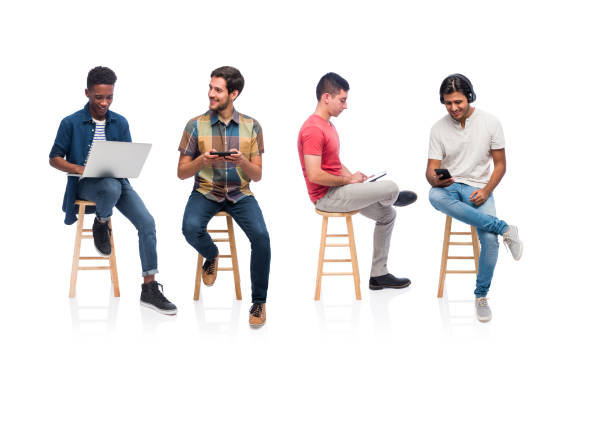 grupa młodych mężczyzn siedzących i korzystających z urządzeń technologicznych - multi ethnic group concentration mobile phone using laptop zdjęcia i obrazy z banku zdjęć