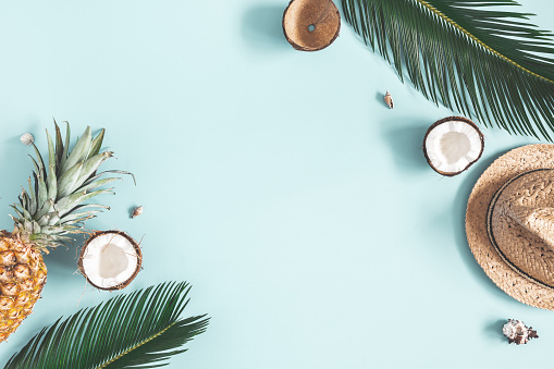 Composición de verano. Hojas de Palmera tropical, sombrero, frutas sobre fondo azul. Concepto de verano. Flat Lay, vista superior, copiar espacio photo