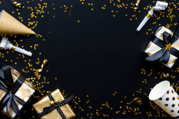 istock Gift boxes in various gold pattern wrapping papers over star shaped golden sequins on a black background. 1149087749