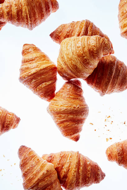 istock Falling fresh french croissants with crumbs on a light background. 1149091172