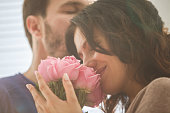 Woman enjoying moment with her husband after receiving roses