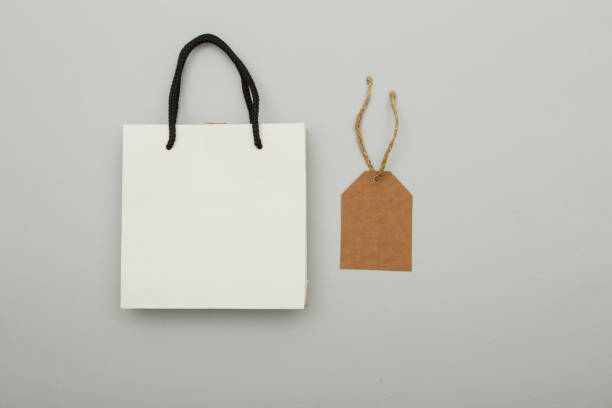 istock White paper bag package on gray background. Place for text. Mock up concept for gift wrapping. 1149094010