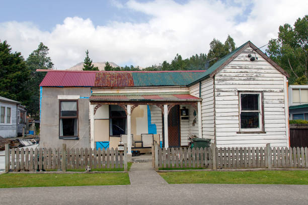 Queenstown, Tasmania: April 03, 2019: A typical detached double fronted bungalow home with a corrugated roof, white picket fence and verandah in Queenstown.