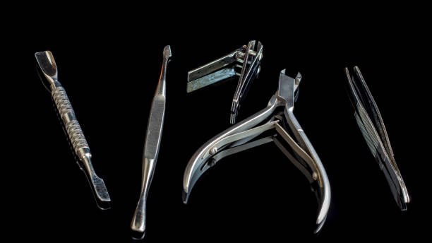 istock Manicure and pedicure accessories on a black glass table. Equipment and tools for nail treatment. Hand care. Scissors,pliers,tweezers and blade on the table.