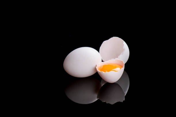 黒の背景に壊れた卵の反射 - visual art growing ストックフォトと画像