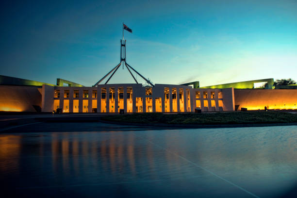 здание парламента выходит на свет незадолго до ночи в канберре - city urban scene canberra parliament house australia стоковые фото и изображения