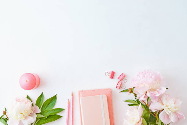istock Blogger or freelancer workspace with notebook and light pink peonies on a white background 1149100114