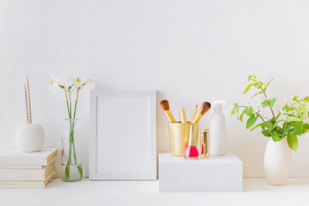 Elegancka toaletka z produktami kosmetycznymi, pędzlami do makijażu i przedmiotami dekoracyjnymi, takimi jak wazony i książki.
