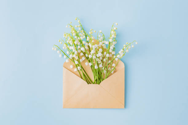 istock Lily of the valley flowers with envelope on a blue background 1149100143