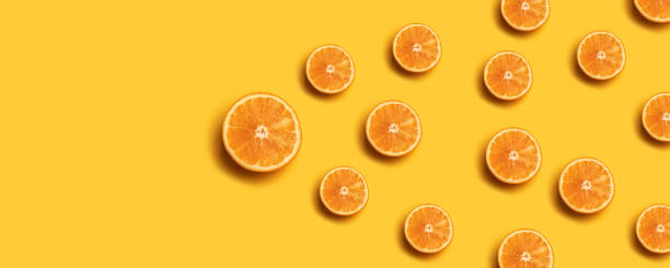 istock Creative summer pattern made of fresh orange slices on yellow background. 1149102439