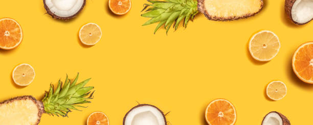 istock Tropical abstract background. Pineapple, lemons, oranges and coconuts on a yellow background. 1149102477
