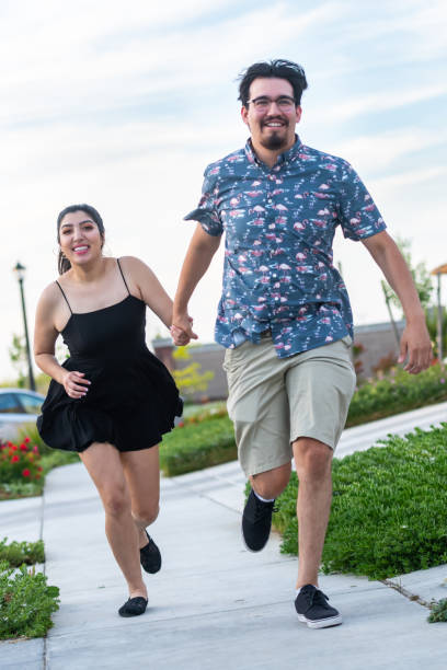 istock Smiling hispanic young couple running holding hands 1149104226
