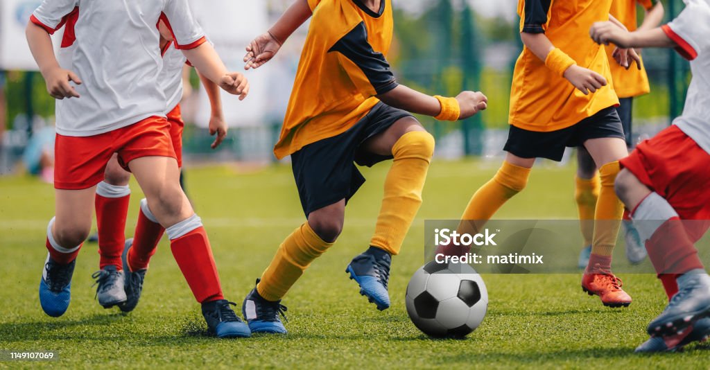 Children Play Soccer Game. Young Boys Running and Kicking Football Ball on Grass Sports Field Boys Stock Photo