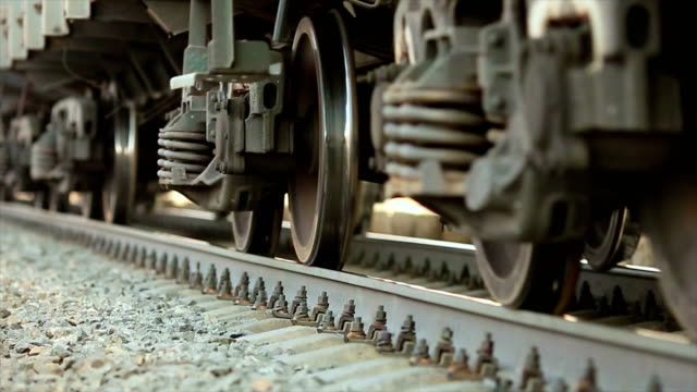 The wheels of old train on the railway track passing by camera. Close up shot.