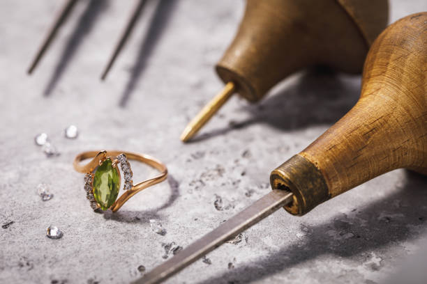 anillo de oro con piedras preciosas en la mesa, rodeado de herramientas de reparación de joyas, de cerca - jewelry craftsperson craft jeweller fotografías e imágenes de stock
