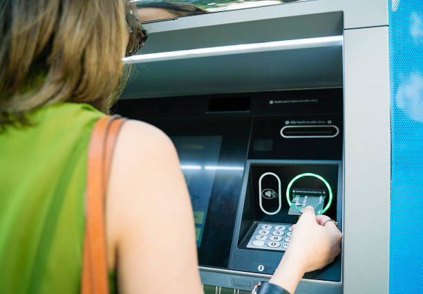 woman inserting atm credit card - cash register register wealth checkout counter imagens e fotografias de stock