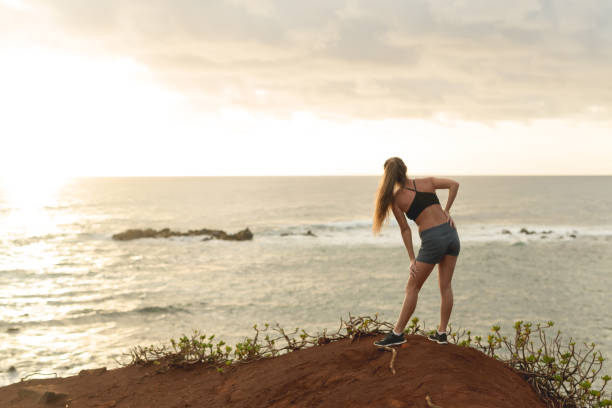 istock Female jogger stretching out before a run along the beach 1149110502