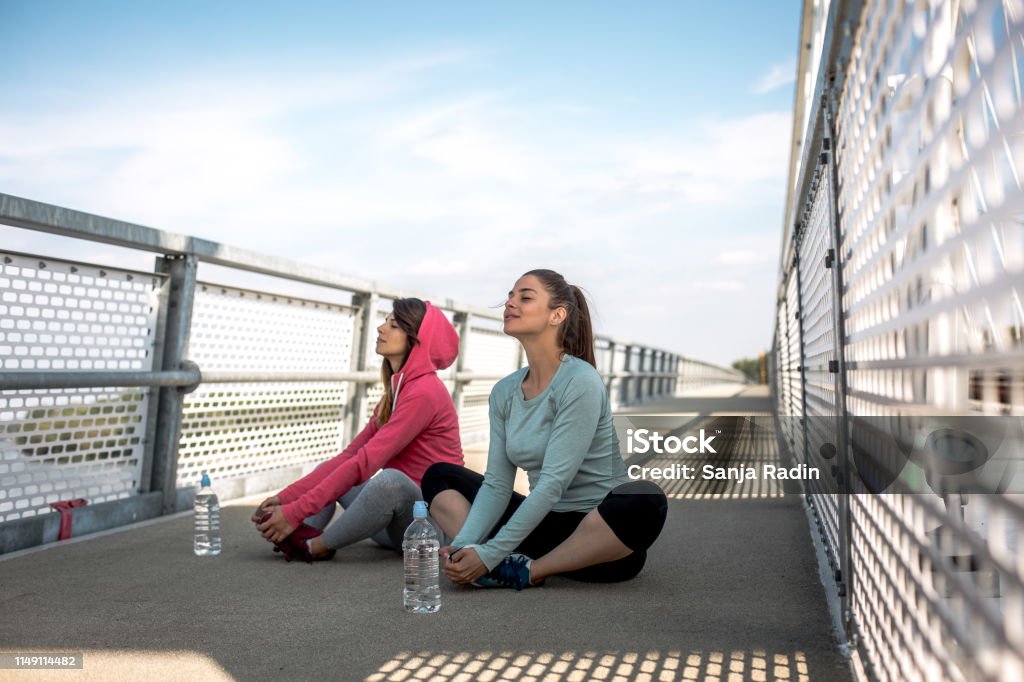 Beautiful women doing streching exercises outdoors. Adult Stock Photo