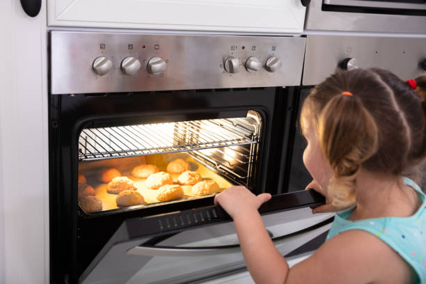 istock Girl Baking Cookies In Oven 1149119550
