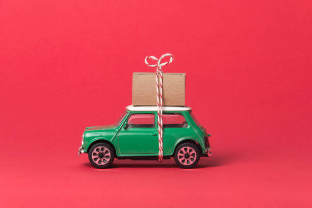 istock Green travel car side on red, with gift box on top 1149124744