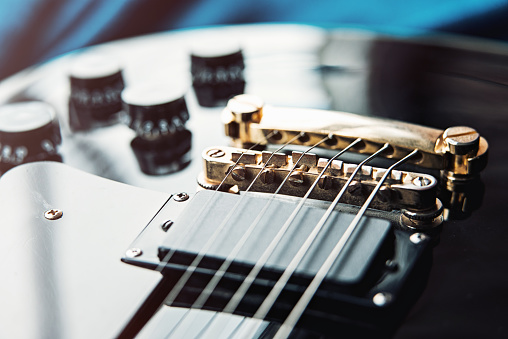 Detail of six-string electric guitar closeup, selective focus. vintage style.