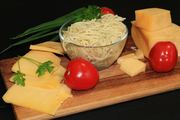 istock Pasta in a cup, cheese and tomatoes on a wooden board 1149131446